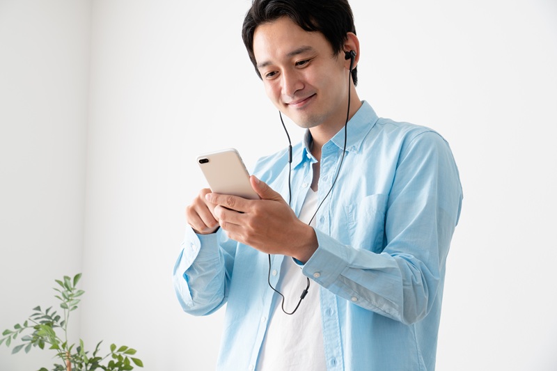 スマホで音楽を聴く男性の写真